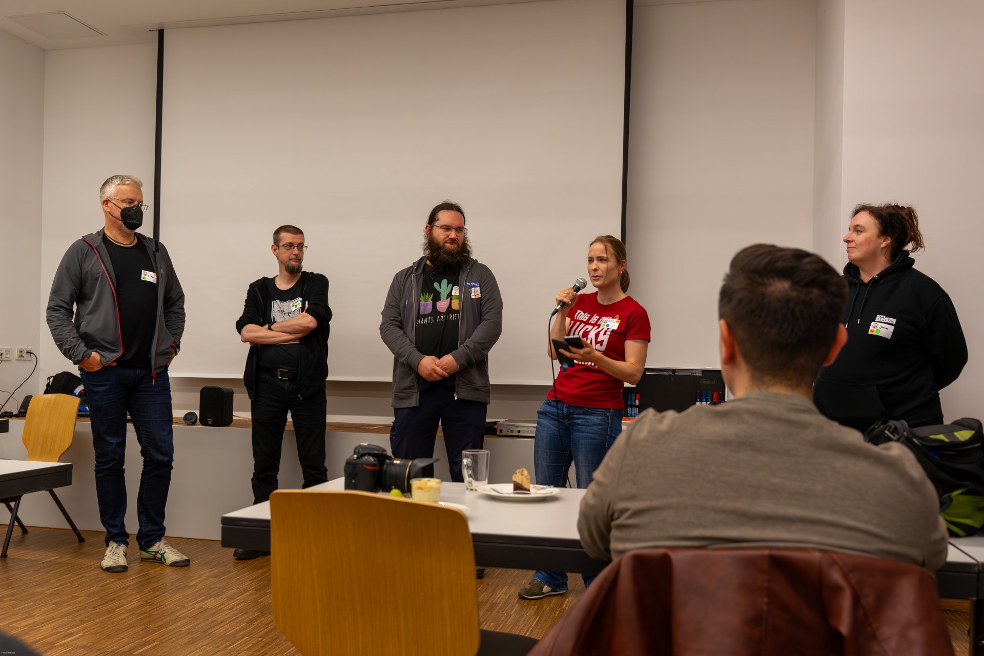 The organization team of osco 2024. Claudius, Dave, Uli, Lissi and Janina. A photo of the five in front of the audience.